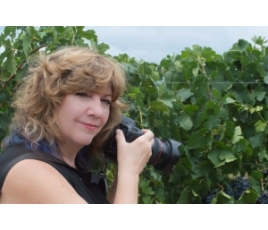 Jenelle Bonifield with camera in the vineyard.